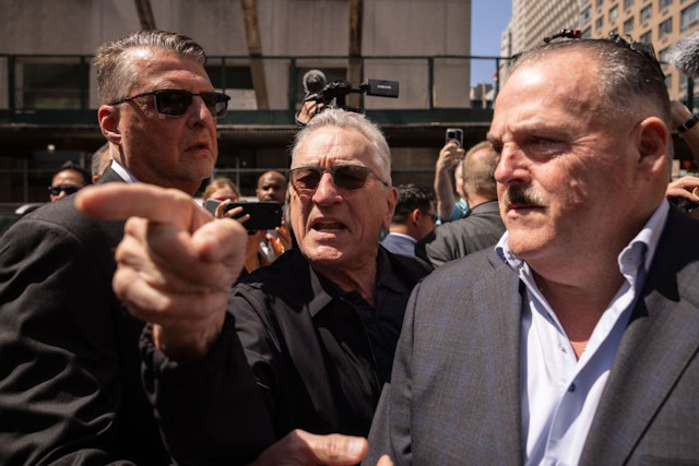 Actor Robert De Niro, center, points to a supporter of former US President Donald Trump, not pictured, as he departs following a news conference outside Manhattan criminal court in New York, US, on Tuesday, May 28, 2024. Former US President Donald Trump faces 34 felony counts of falsifying business records as part of an alleged scheme to silence claims of extramarital sexual encounters during his 2016 presidential campaign. Photographer: Yuki Iwamura/Bloomberg via Getty Images