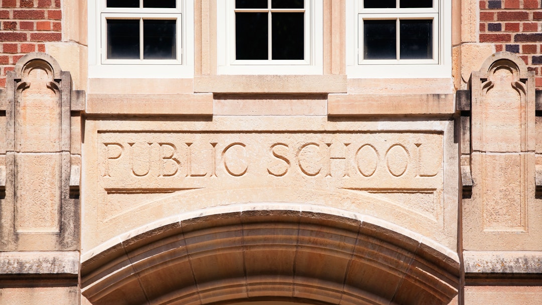 BanksPhotos. Getty Images. A Public School sign carved in granite about the entrance to an old high school.