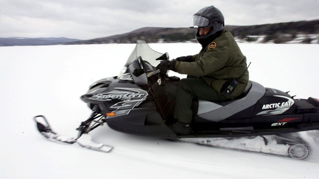 NORTON, VT - MARCH 22: U.S. Border Patrol Agent Paul Mulcahy rides a snowmobile while looking for signs of illegal aliens during a patrol on a frozen lake that splits the Canadian territory behind him and the U.S. March 21, 2006 near Norton, Vermont.