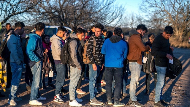 A group of migrants are processed by Border Patrol after crossing the river illegally near the highway on February 4, 2024 outside Eagle Pass, Texas.