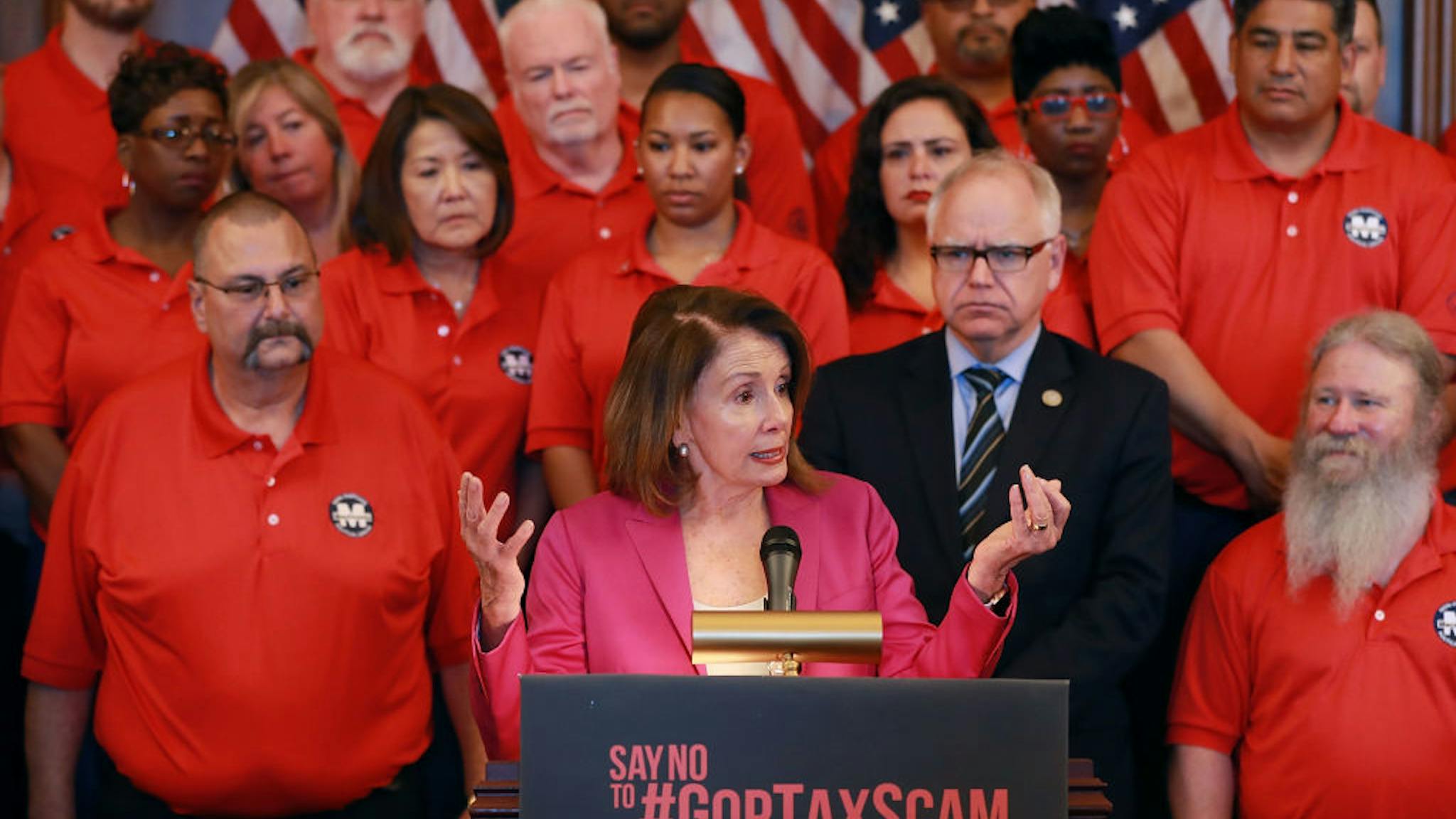 Nancy Pelosi Joins Machinists Union Members To Discuss GOP Tax Policy WASHINGTON, DC - MAY 09: House Minority Leader Nancy Pelosi (D-CA) (C) addresses members of the Machinists Union International with union president Robert Martinez (L) and Rep. Tim Walz (D-MN) (2nd R) in the Rayburn Room at the U.S. Capitol May 9, 2018 in Washington, DC. Pelosi spoke the the rally of machinists about last year's Republican Tax Cuts and Jobs Act, which she claimed, "helped pad the profits of wealthy corporations shutting down American plants and laying off American workers."