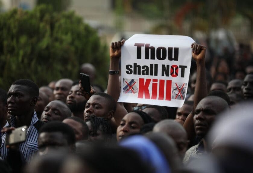 Christians faithfuls hold signs as they march on the streets of Abuja during a prayer and penance for peace and security in Nigeria in Abuja on March 1, 2020. - The Catholic Bishops of Nigeria gathered faithfuls as well as other Christians and other people to pray for security and to denounce the barbaric killings of Christians by the Boko Haram insurgents and the incessant cases of kidnapping for ransom in Nigeria. (Photo by Kola SULAIMON / AFP)