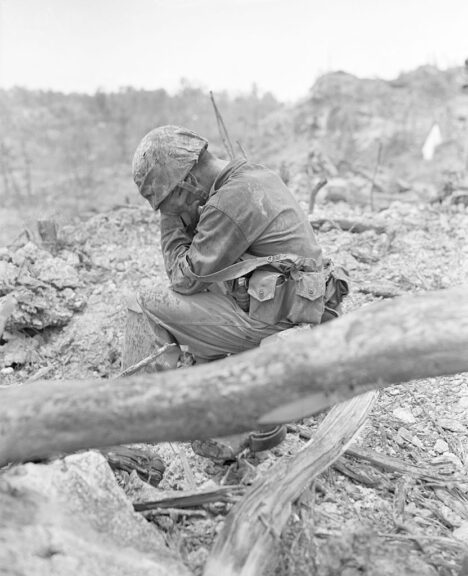 (Original Caption) 9/26/1944-Peleliu Island: Weary and exhausted after the tough battle for Hill 200 Near Peleliu Airpoet, this leathr neck sits down amidst the battle rubble and weeps. According to latest reports, the marines are making steady progress on the Island, although heavy fighting continues.