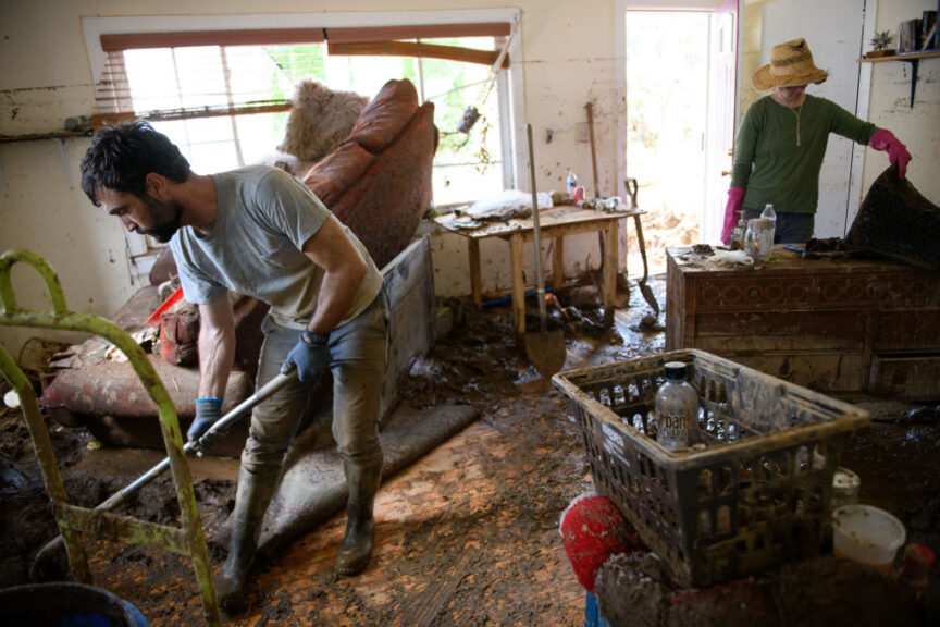 SWANNANOA, NORTH CAROLINA - OCTOBER 02: Mark Dempsey, left, and Emily Ogburn salvage items and begin to mud out Dempsey's home on October 2, 2024 in Swannanoa, North Carolina. According to reports, at least 160 people have been killed across the southeastern U.S., and more than a million are without power due to the storm. The White House has approved disaster declarations in multiple southern states, freeing up federal emergency management money and resources. (Photo by Melissa Sue Gerrits/Getty Images)