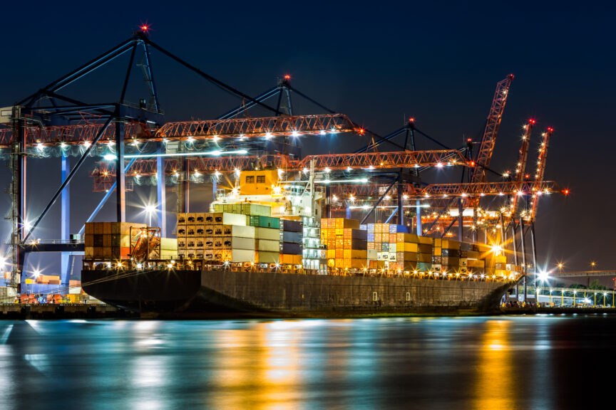 Cargo ship loaded in New York container terminal at night viewed from Elizabeth NJ across Elizabethport reach. Ultima_Gaina. Getty Images.