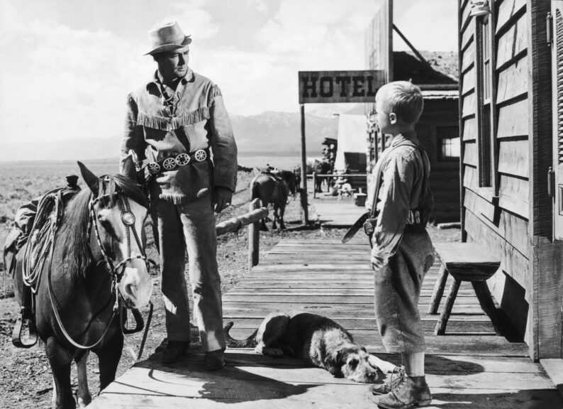 1953: American actor Alan Ladd stands next to a horse and talks to child actor Brandon De Wilde in a still from director George Stevens' western film, 'Shane,' based on the novel by Jack Schaefer. (Photo by Hulton Archive/Getty Images)