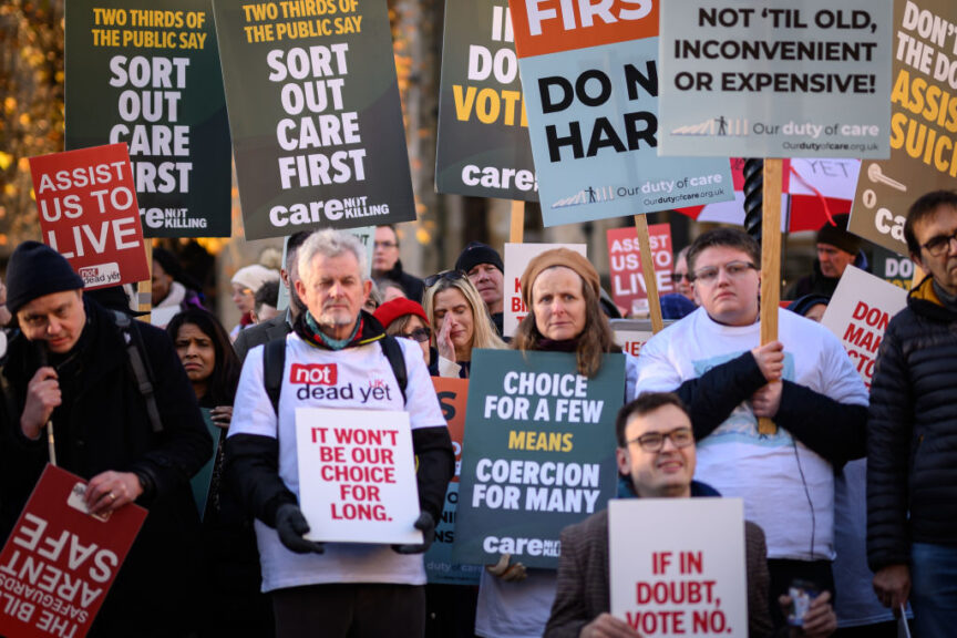 LONDON, ENGLAND - NOVEMBER 29: Supporters of the "Not Dead Yet" campaign, which opposes the Assisted Dying Bill, react outside the Houses of Parliament as news breaks that the Bill has passed the first stage, on November 29, 2024 in London, England. Today Members of Parliament are debating and voting on the second reading of the Terminally Ill Adults (End of Life) Bill, also referred to as the Assisted Dying Bill, which would give adults in England and Wales the right to choose to end their lives. The landmark private member's bill, proposed by backbench Labour MP Kim Leadbeater, would allow terminally ill people - who meet a set of safeguarding criteria - to seek medical assistance to die at a time of their choosing. (Photo by Leon Neal/Getty Images)