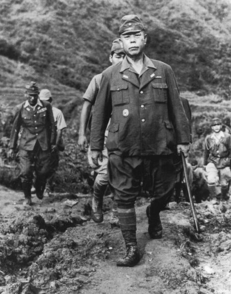 circa 1945: Japanese army general Tomoyuki Yamashita uses a cane while walking along a dirt road ahead of several soldiers. Yamashita was known as the 'Tiger of Malaya' for his leadership of the Japanese forces against the British troops in the Philippines. (Photo by US Army/Getty Images)