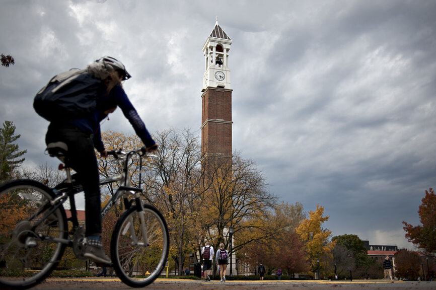 A student rides a bicycle past the bell tower on the campus of Purdue University in West Lafayette, Indiana, U.S., on Monday, Oct. 22, 2012. Administrative costs on college campuses are soaring, crowding out instruction at a time of skyrocketing tuition and $1 trillion in outstanding student loans. At Purdue and other U.S. college campuses, bureaucratic growth is pitting professors against administrators and sparking complaints that tight budgets could be spent more efficiently. Photographer: Daniel Acker/Bloomberg via Getty Images