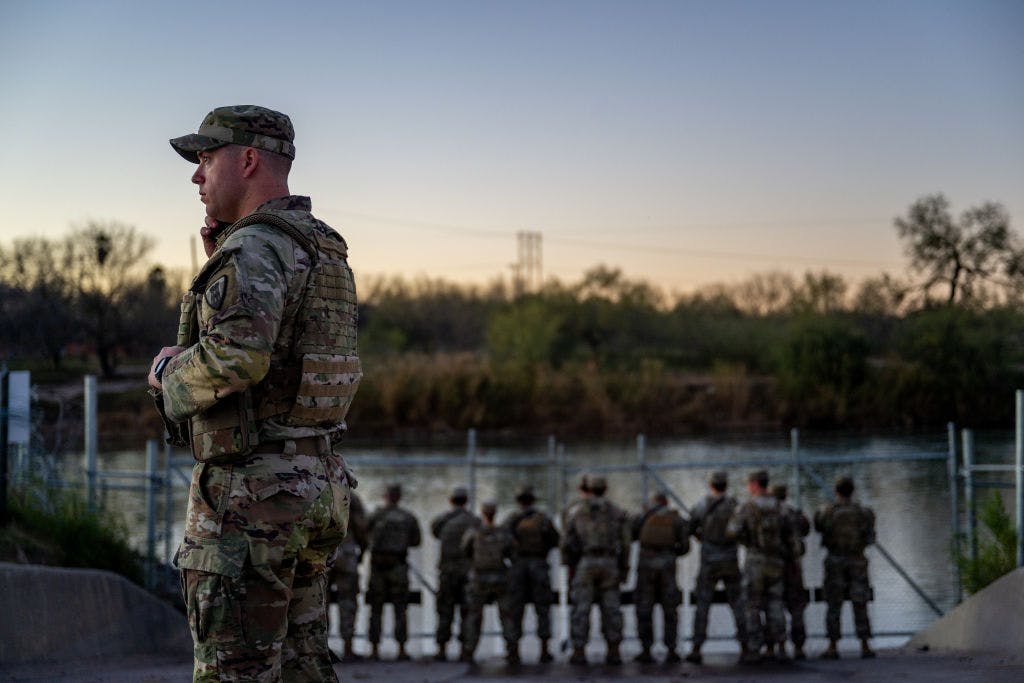 EAGLE PASS, TEXAS - JANUARY 12: National Guard soldiers stand guard on the banks of the Rio Grande river at Shelby Park on January 12, 2024 in Eagle Pass, Texas. The Texas National Guard continues its blockade and surveillance of Shelby Park in an effort to deter illegal immigration. The Department of Justice has accused the Texas National Guard of blocking Border Patrol agents from carrying out their duties along the river. (Photo by Brandon Bell/Getty Images)