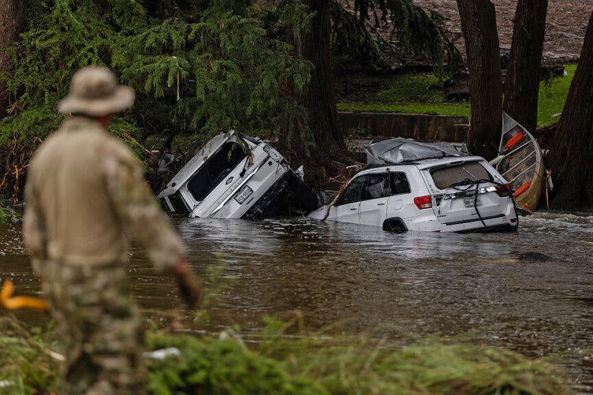 HUNT, TEXAS - JULY 6: Vehicles sit submerged as a search and rescue worker looks through debris for any survivors or remains of people swept up in the flash flooding on July 6, 2025 in Hunt, Texas. Heavy rainfall caused flooding along the Guadalupe River in central Texas with multiple fatalities reported. (Photo by Jim Vondruska/Getty Images)