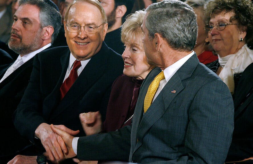 WASHINGTON - MAY 03: Dr. James Dobson, founder of Focus on the Family (L), shakes hands with U.S. President George W. Bush (R) as Dobson's wife, Shirley Dobson, looks on during the National Day of Prayer ceremony at the White House May 3, 2007 in Washington, DC. The program included prayers and meditations from Christian and Jewish leaders and a performance by the US Army Chorus. (Photo by Chip Somodevilla/Getty Images)