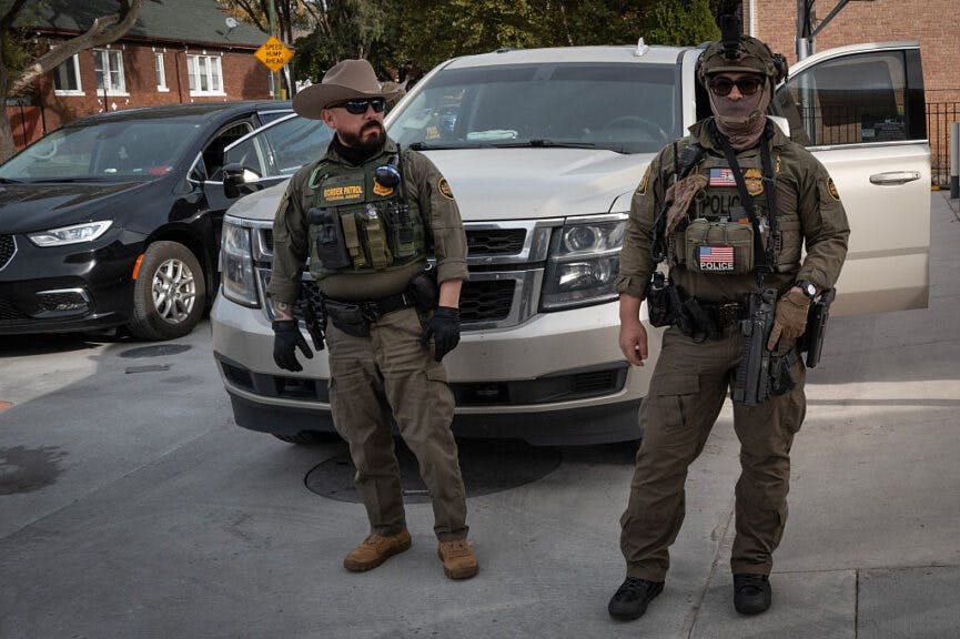 CHICAGO, ILLINOIS - NOVEMBER 06: Federal agents stand guard as they are confronted by residents after making a stop while driving in a caravan through the Brighton Park neighborhood on November 06, 2025 in Chicago, Illinois. Federal agents participating in Operation Midway Blitz, engage in daily patrols through Chicago neighborhoods and surrounding suburbs searching for undocumented immigrants. (Photo by Scott Olson/Getty Images)