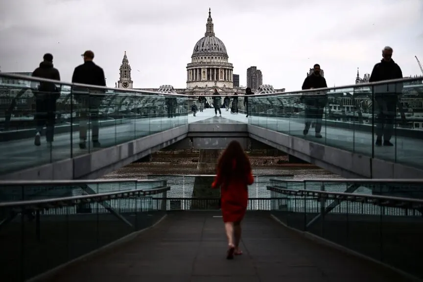 Pedestrians walk across the Millennium Bridge above the River Thames in central London on April 16, 2026. Britain's economy grew much stronger than expected in February, prior to the start of the Middle East war, official data showed on April 16 ahead of a likely hit from the US-Iran conflict. (Photo by Henry NICHOLLS / AFP via Getty Images)