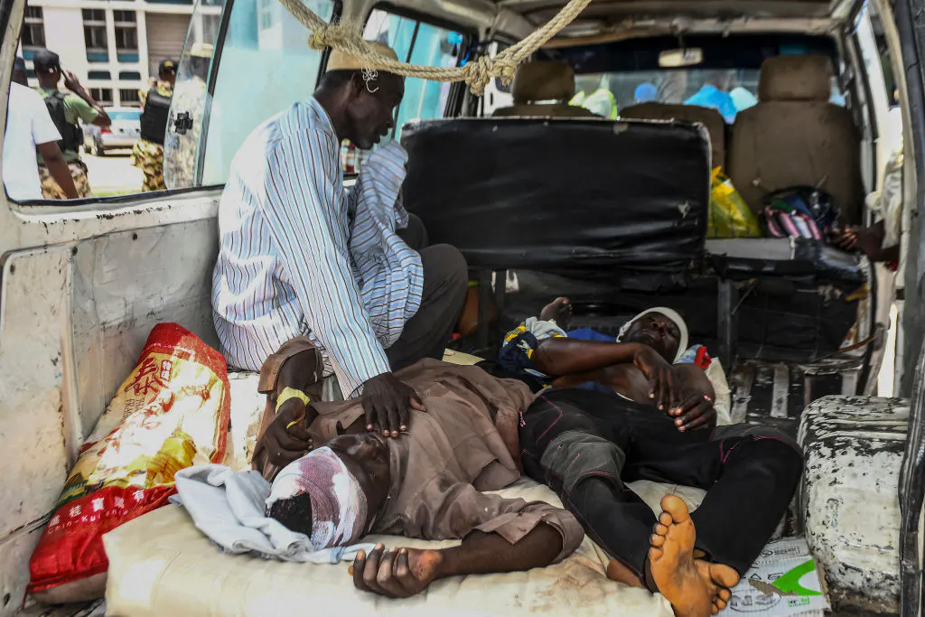 Injured men lay in a van as they arrive for treatment after a wave of suicide attacks in the North East of Nigeria, in Maiduguri on June 29, 2024. At least 18 people were killed and 19 seriously wounded in suicide attacks targeting a wedding, a hospital and a funeral in northeastern Nigeria on June 29, authorities said. The region has been scarred by more than a decade of violence by jihadist group Boko Haram, which did not immediately claim responsibility for the string of attacks. (Photo by Audu MARTE / AFP) 