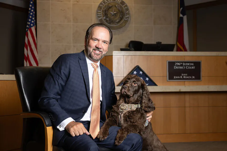 udge John Roach Jr., the presiding judge of the 296th District Court, poses for a photo with his Boykin Spaniel named Justice in his courtroom in the Collin County Courthouse in McKinney, TX, Friday, June 12, 2026.